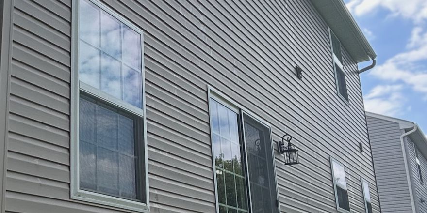 Clean windows reflecting the sky on a two story house